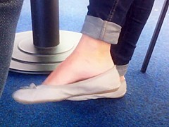 Candid dangling in grey flat barefeet