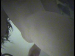Nude girl in dressing room bends over searching the cloths