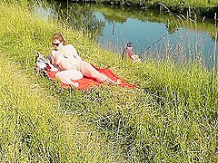 Nudist Beach. Public Nudity. Sexy Milf Without Panties And Bra Sunbathes Naked Is Not Shy About Fish