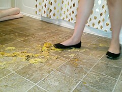 Suzi walks over unpeeled bananas, on floor, wearing her black ballet flats