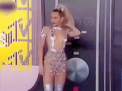 Scantily clad Miley Cyrus poses for photographers