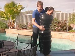Julia in an inflatable latex cocoon in pool