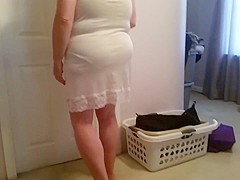 putting on her girdle, under garment over her big tits,