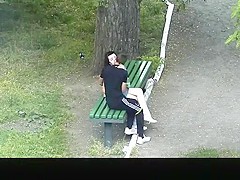 Teen couple making out in public park bench