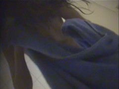 A suntanned girl is wiping her sexy body after shower