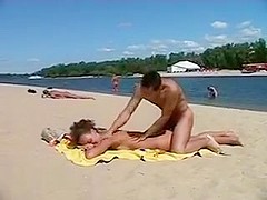 Girl at nudist beach stripping off her clothes and smothered with cream