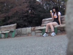 Upskirt and downblouse of girl eating ice cream on the bench