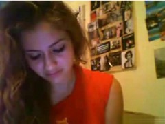 Hot brunette girl with small tits fingers her pussy on her bed