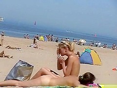 Sunny day at the public beach with two nudist girls