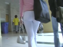 Fit brunette in white skintight pants walks in a student hall candid porn